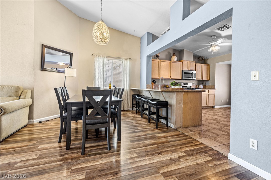 1624 Palmae Way Las Vegas, NV 89128 - Photo 4 of 18 An inviting open-concept area blends dining with a well-appointed kitchen, featuring a practical breakfast bar.