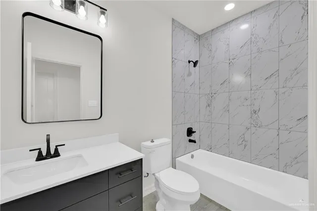 a bathroom with a toilet a sink a tub and mirror