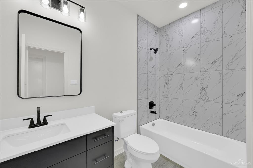 2612 Robin Road, Unit #3 Weslaco, TX 78596 - Photo 12 of 23 a bathroom with a toilet a sink a tub and mirror