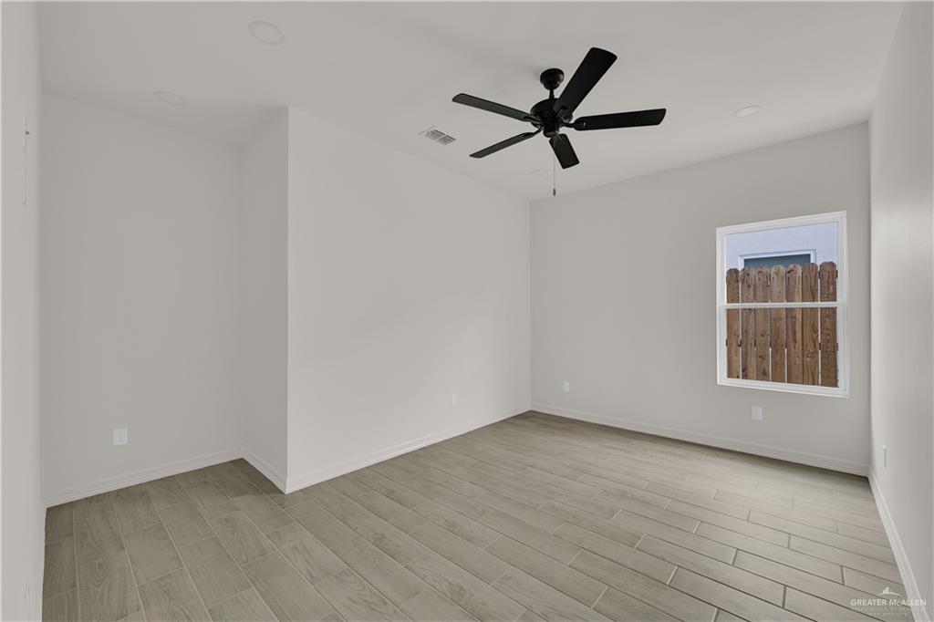 2612 Robin Road, Unit #3 Weslaco, TX 78596 - Photo 13 of 23 an empty room with wooden floor and windows