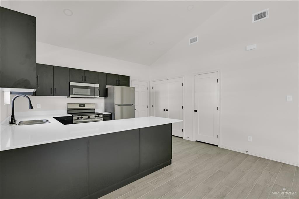 2612 Robin Road, Unit #3 Weslaco, TX 78596 - Photo 7 of 23 a kitchen with stainless steel appliances a sink a stove a microwave a sink a refrigerator and cabinets