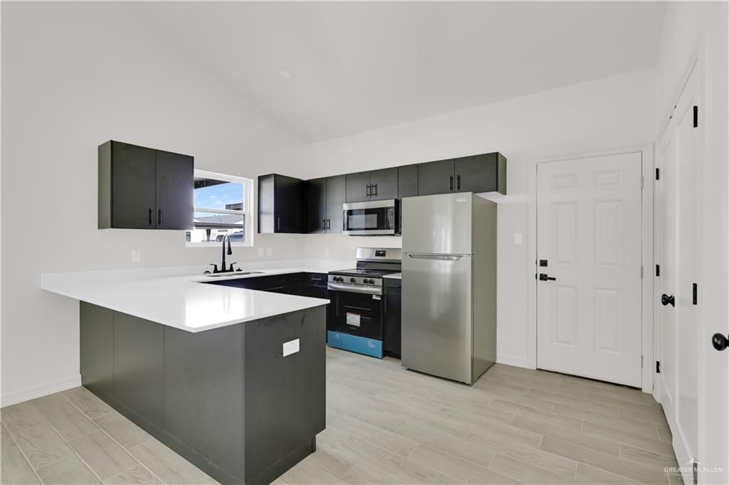 2612 Robin Road, Unit #3 Weslaco, TX 78596 - Photo 8 of 23 a kitchen with stainless steel appliances granite countertop a refrigerator a sink a stove a microwave and a refrigerator