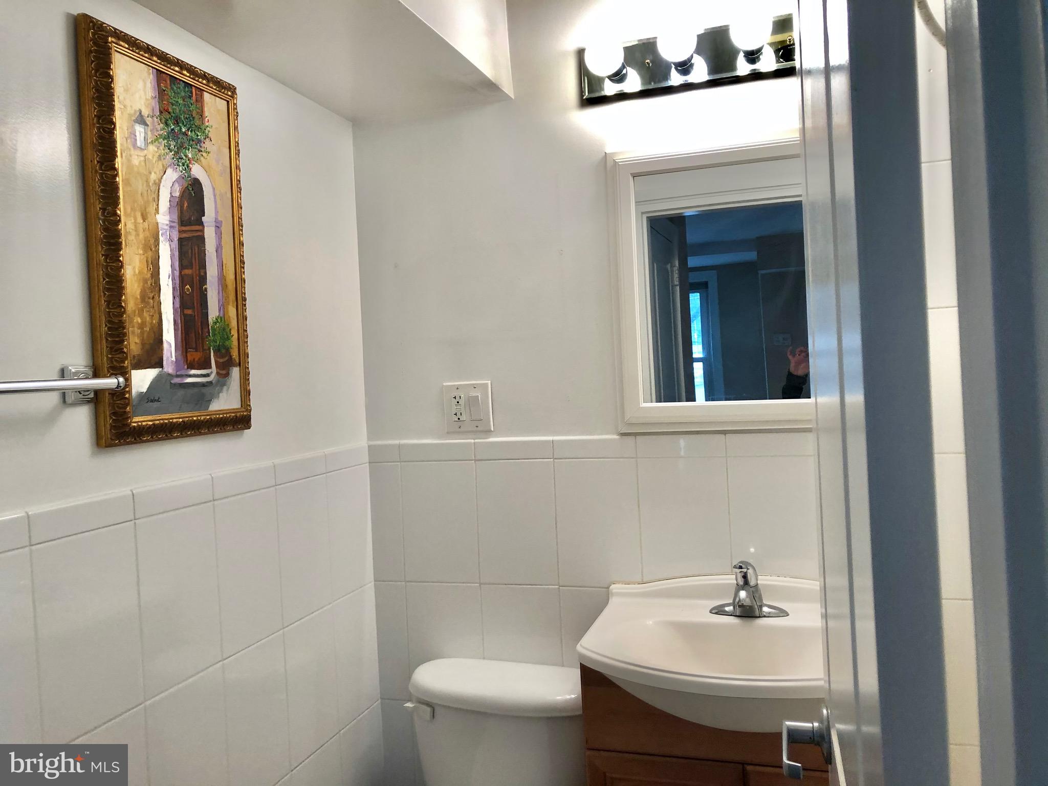 4840 MacArthur Boulevard Northwest, Unit 501 Washington, DC 20007 - Photo 14 of 24 a bathroom with a sink a toilet and mirror