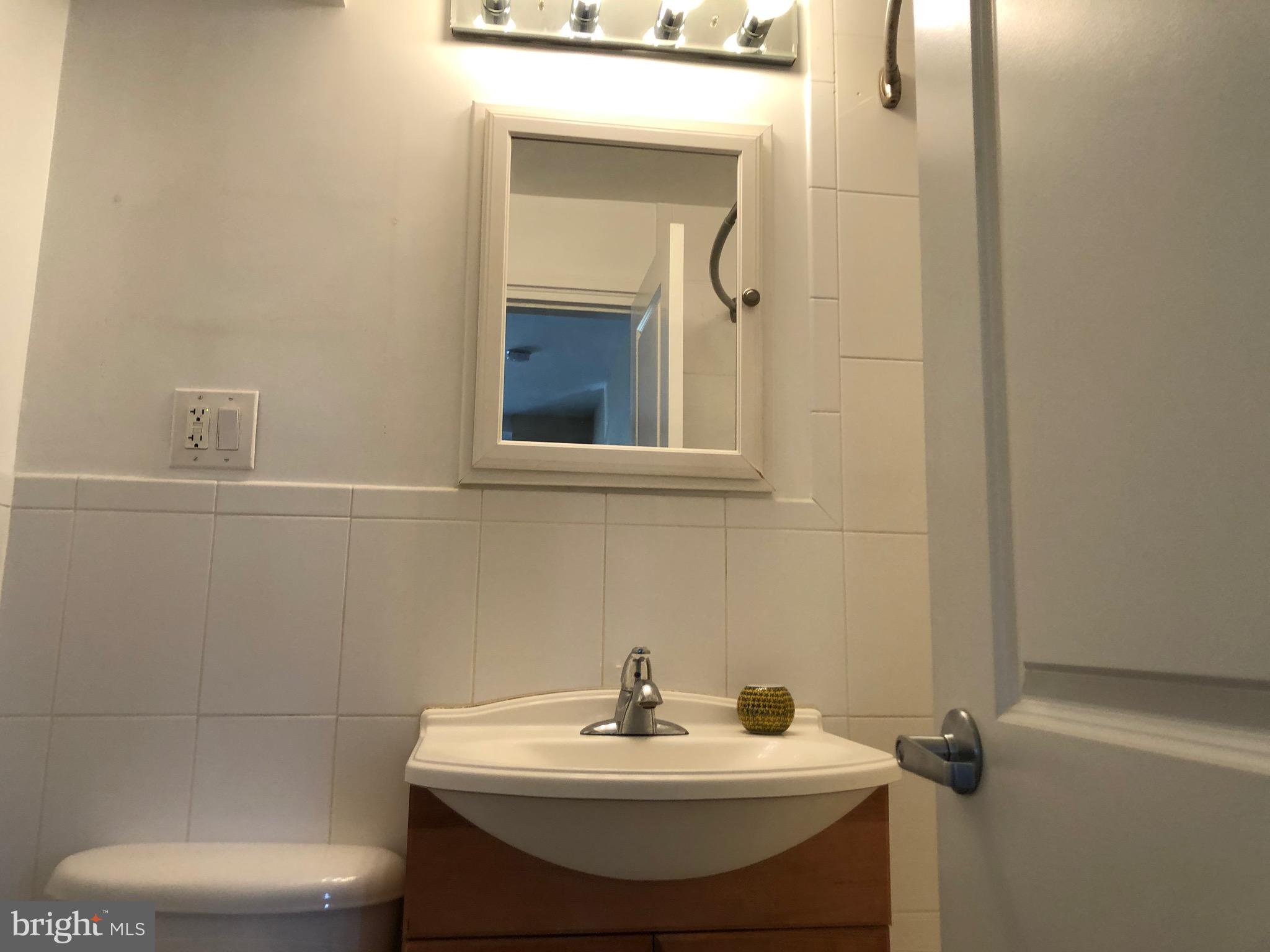 4840 MacArthur Boulevard Northwest, Unit 501 Washington, DC 20007 - Photo 15 of 24 a bathroom with a sink toilet and a mirror
