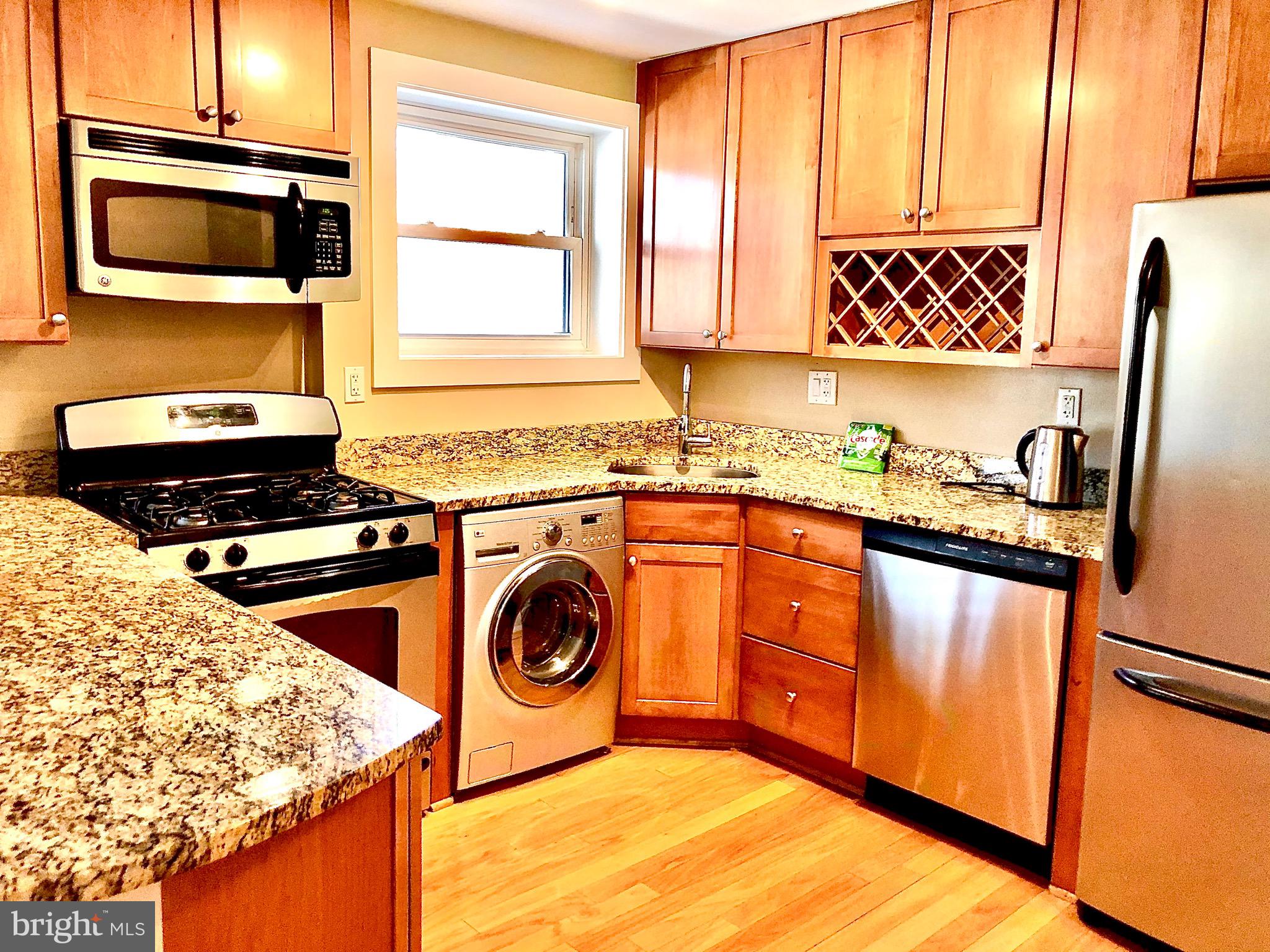 4840 MacArthur Boulevard Northwest, Unit 501 Washington, DC 20007 - Photo 7 of 24 a kitchen with a stove a sink and a microwave