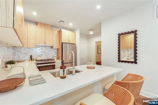 a kitchen with stainless steel appliances granite countertop a sink and a refrigerator