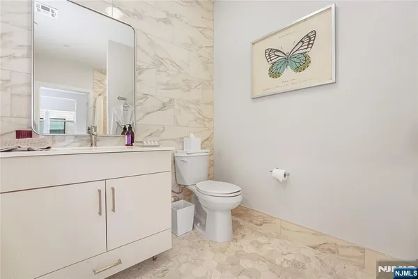 a bathroom with a toilet sink vanity and mirror