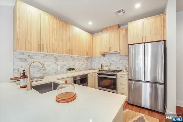 a kitchen with stainless steel appliances a refrigerator sink and stove