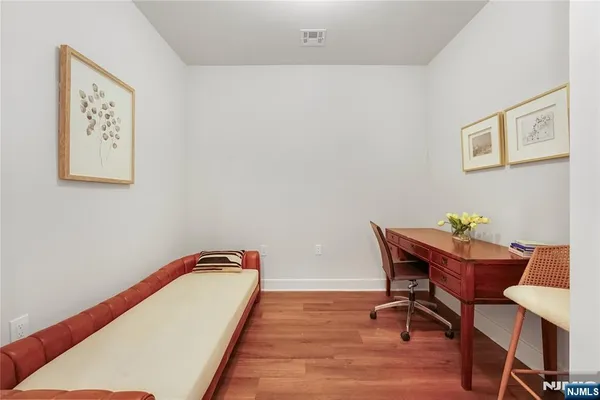 a view of a workspace with furniture and wooden floor