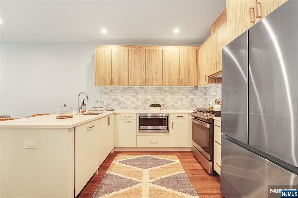 434 Springfield Avenue, Unit 105 Berkeley Heights, NJ 07922 - Photo 4 of 19 a kitchen with stainless steel appliances granite countertop a sink stove and refrigerator