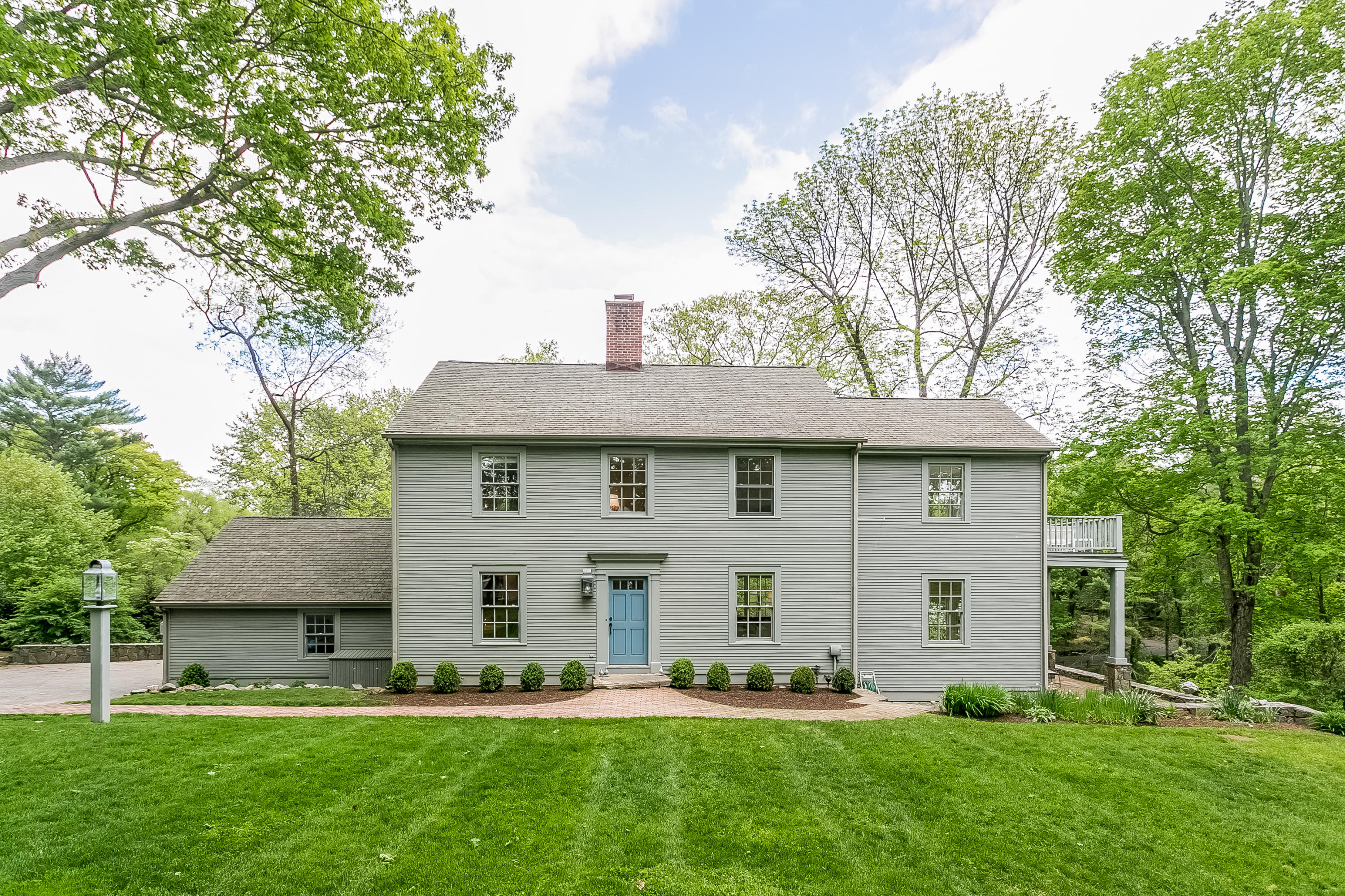 a front view of a house with a garden and trees