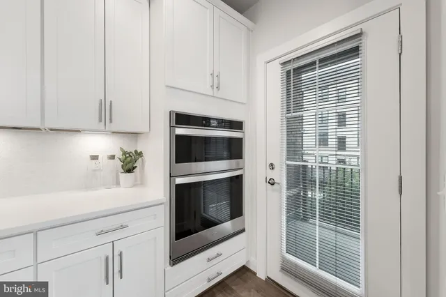 a kitchen with white cabinets and a stove