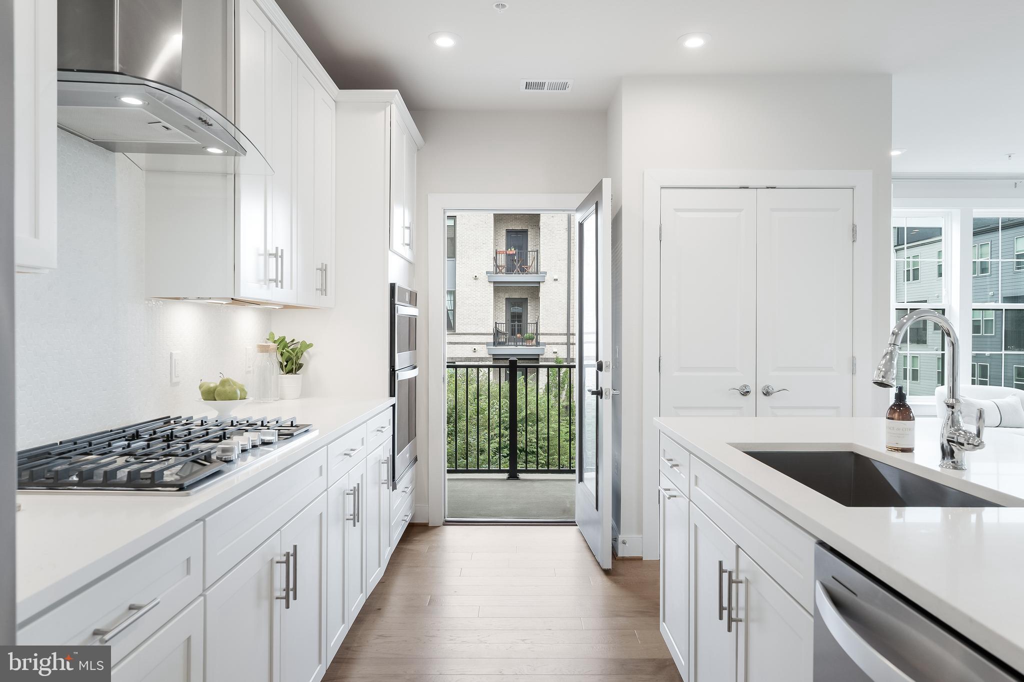 2320 Field Point Road, Unit 201 Herndon, VA 20171 - Photo 17 of 47 a kitchen with stainless steel appliances kitchen island wooden cabinets a sink and a stove