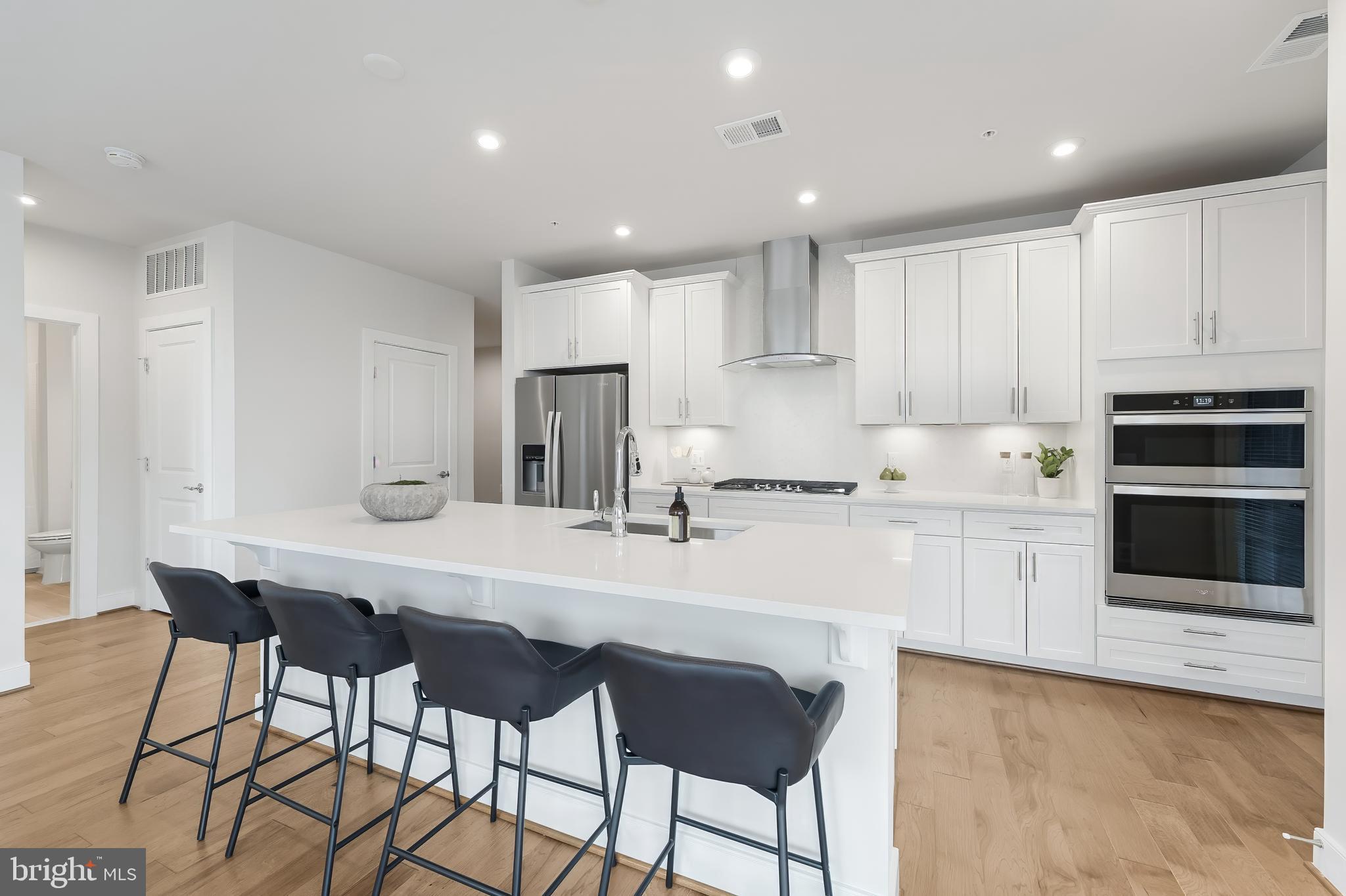 2320 Field Point Road, Unit 201 Herndon, VA 20171 - Photo 9 of 47 a kitchen with stainless steel appliances a sink a stove a refrigerator with white cabinets and wooden floor