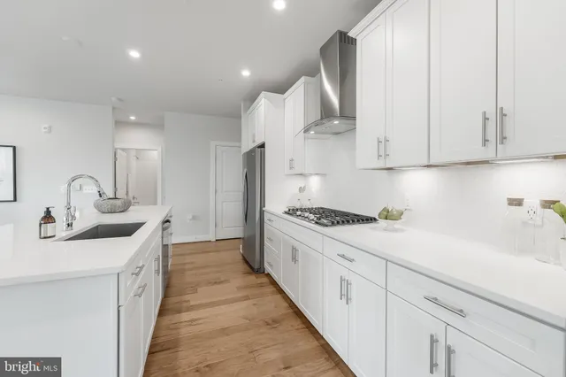 a kitchen with stainless steel appliances granite countertop a sink stove and cabinets