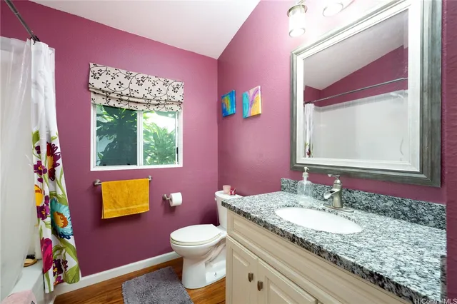 a bathroom with a granite countertop toilet sink and mirror
