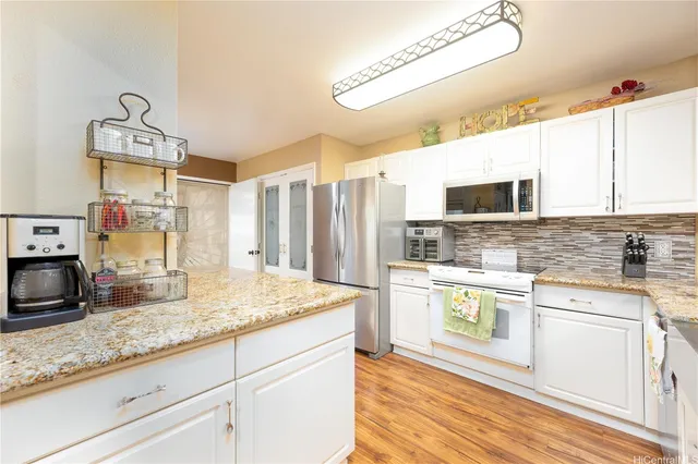 a kitchen with stainless steel appliances granite countertop a sink a stove top oven a chimney and a counter space