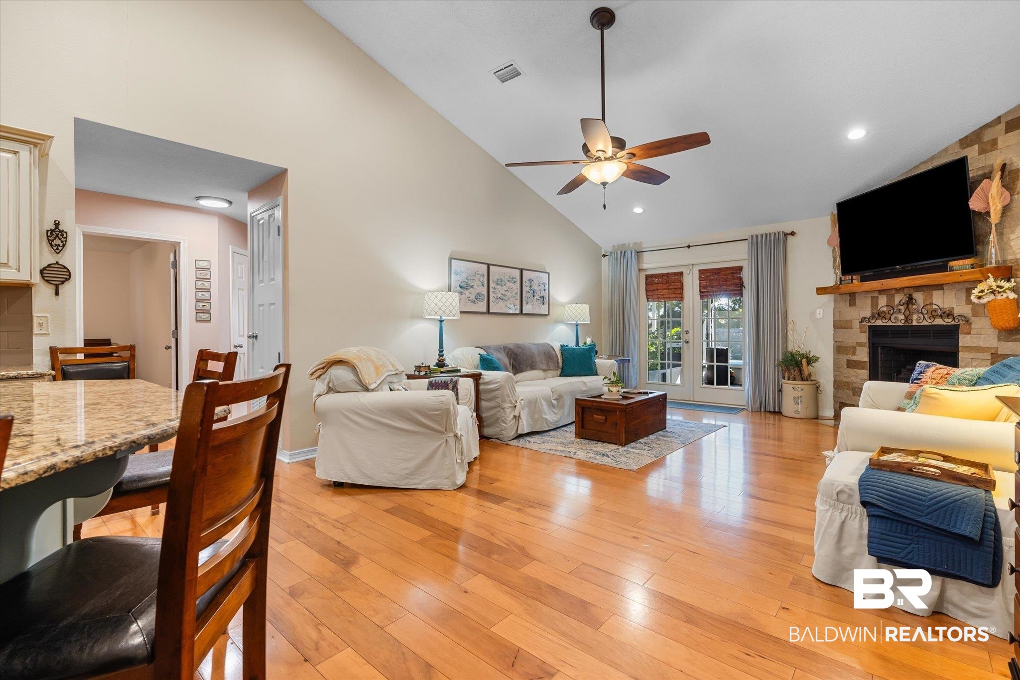 356 Collinwood Loop Foley, AL 36535 - Photo 3 of 21 Living room featuring a stone fireplace, ceiling fan, high vaulted ceiling, and light wood-type flooring