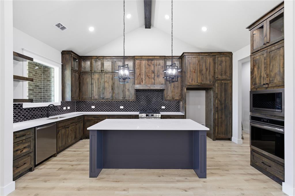 713 Anne Road Van Alstyne, TX 75495 - Photo 6 of 29 Modern kitchen featuring wood-finish cabinetry and a dark tile backsplash