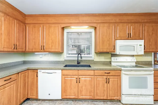 a kitchen with stainless steel appliances granite countertop a sink cabinets and a window