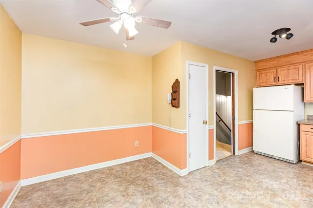a view of a livingroom with a chandelier fan and a refrigerator