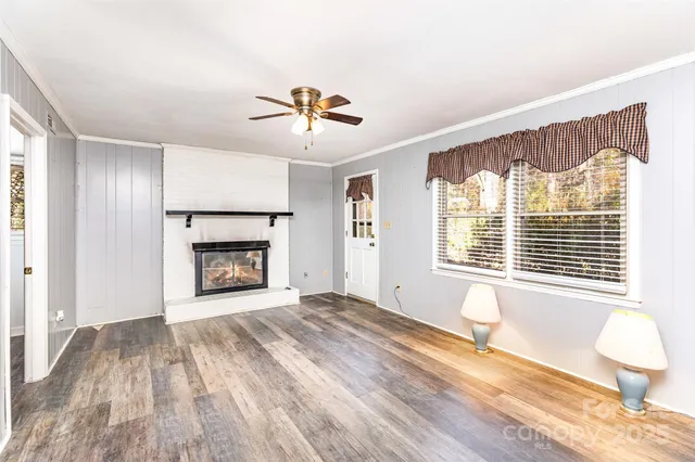 a view of an empty room with a window and fireplace