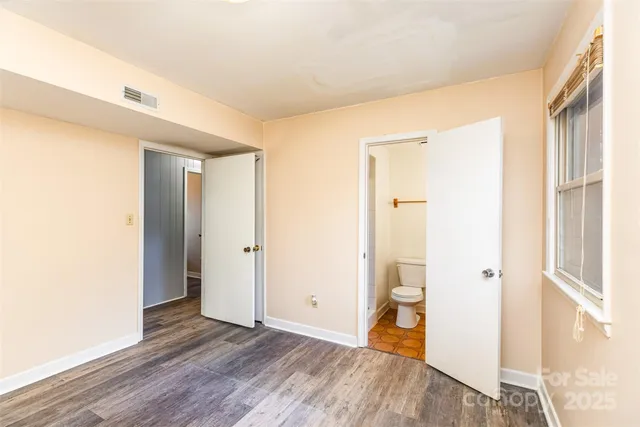 a big room with wooden floor and a bathroom