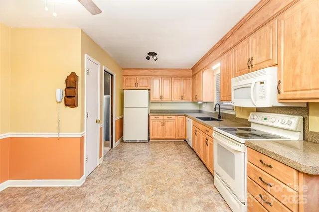 a large kitchen with stainless steel appliances granite countertop a refrigerator and a stove top oven