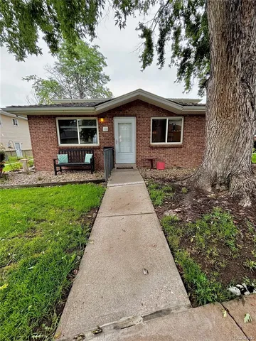 a front view of house with yard and trees in the background