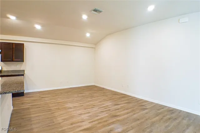 a view of empty room with wooden floor