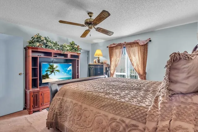 a bed room with a bed mirror and a flat tv screen