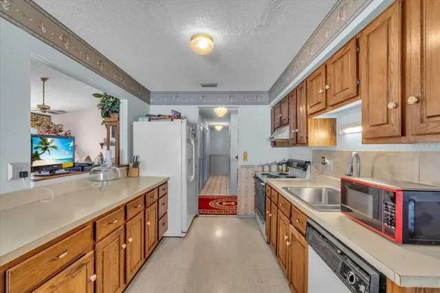a kitchen with stainless steel appliances a sink and a refrigerator