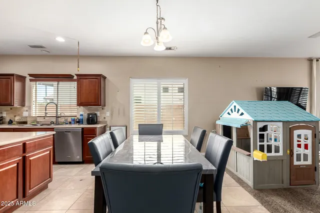 a kitchen with stainless steel appliances granite countertop a kitchen island hardwood floor sink stove dining table and chairs