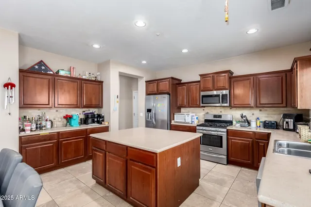 a kitchen with stainless steel appliances a sink stove refrigerator and cabinets