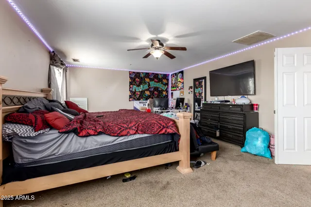 a bedroom with a bed and a flat tv screen on the dresser