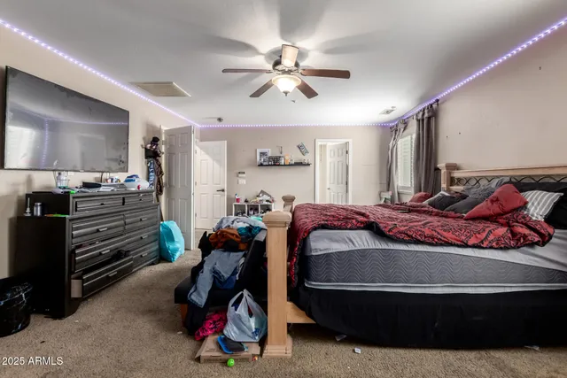 a bed room with a bed and a ceiling fan