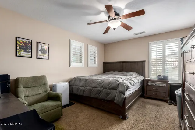 a bedroom with a bed next to a window with kitchen view