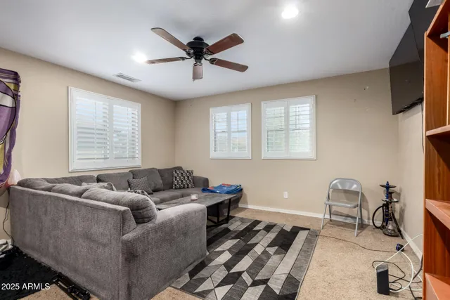 a living room with furniture a ceiling fan and a window