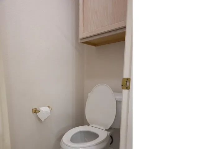 a bathroom with a toilet and a mirror