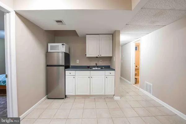 a kitchen with a refrigerator and white cabinets