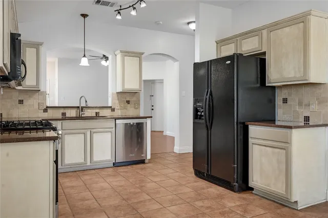 a kitchen with stainless steel appliances granite countertop a refrigerator a stove a sink and a microwave