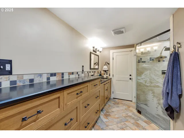 a bathroom with a granite countertop sink mirror and shower