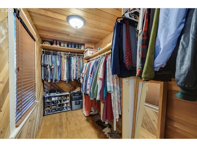 a view of walk in closet with clothes and shoes