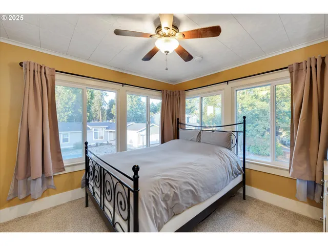 a bed sitting in a bedroom next to a window