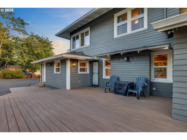 a backyard of a house with wooden deck and furniture