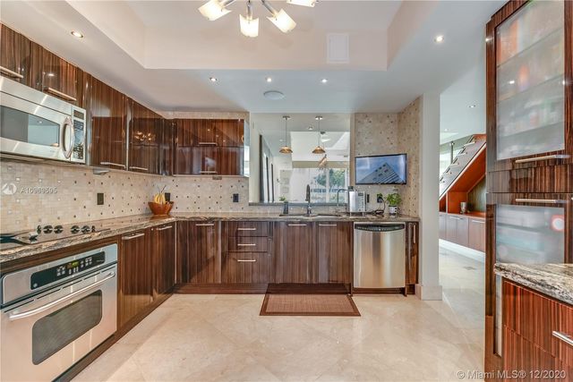 a kitchen with stainless steel appliances granite countertop a stove a sink dishwasher and a refrigerator