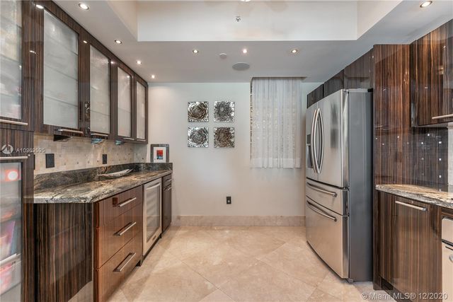 a kitchen with stainless steel appliances granite countertop a refrigerator a stove and a sink