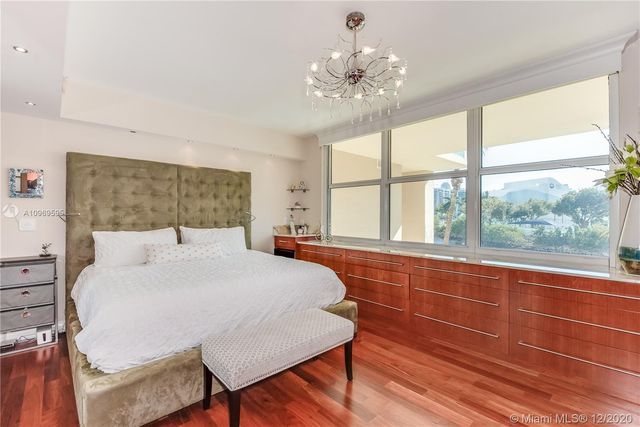 a bedroom with a large bed and a chandelier