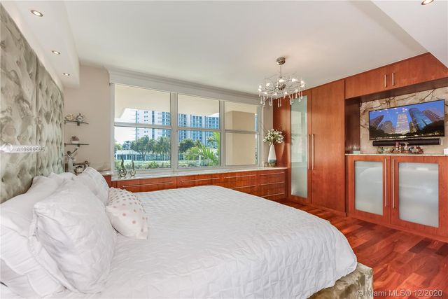 a bedroom with a large bed and a flat screen tv