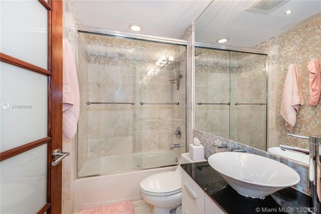 a bathroom with a sink toilet a mirror and shower